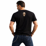 Man wearing a black t-shirt with a skull design on the back, standing against a white background.